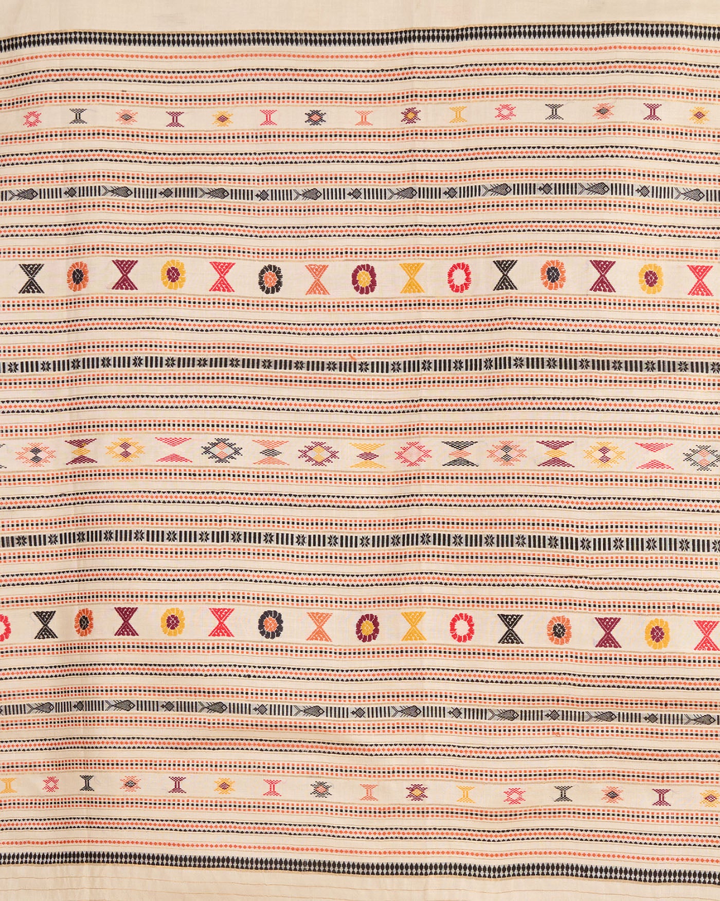 Close up of white kosa silk saree with traditional colourful silk thread motifs on display.