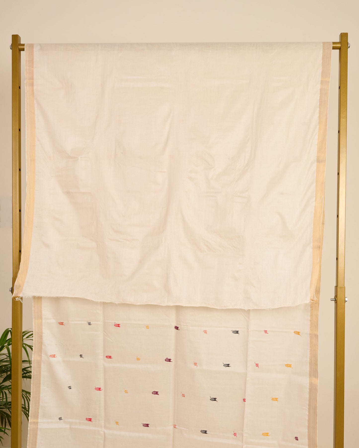 White kosa silk saree with traditional colourful silk thread motifs on display.