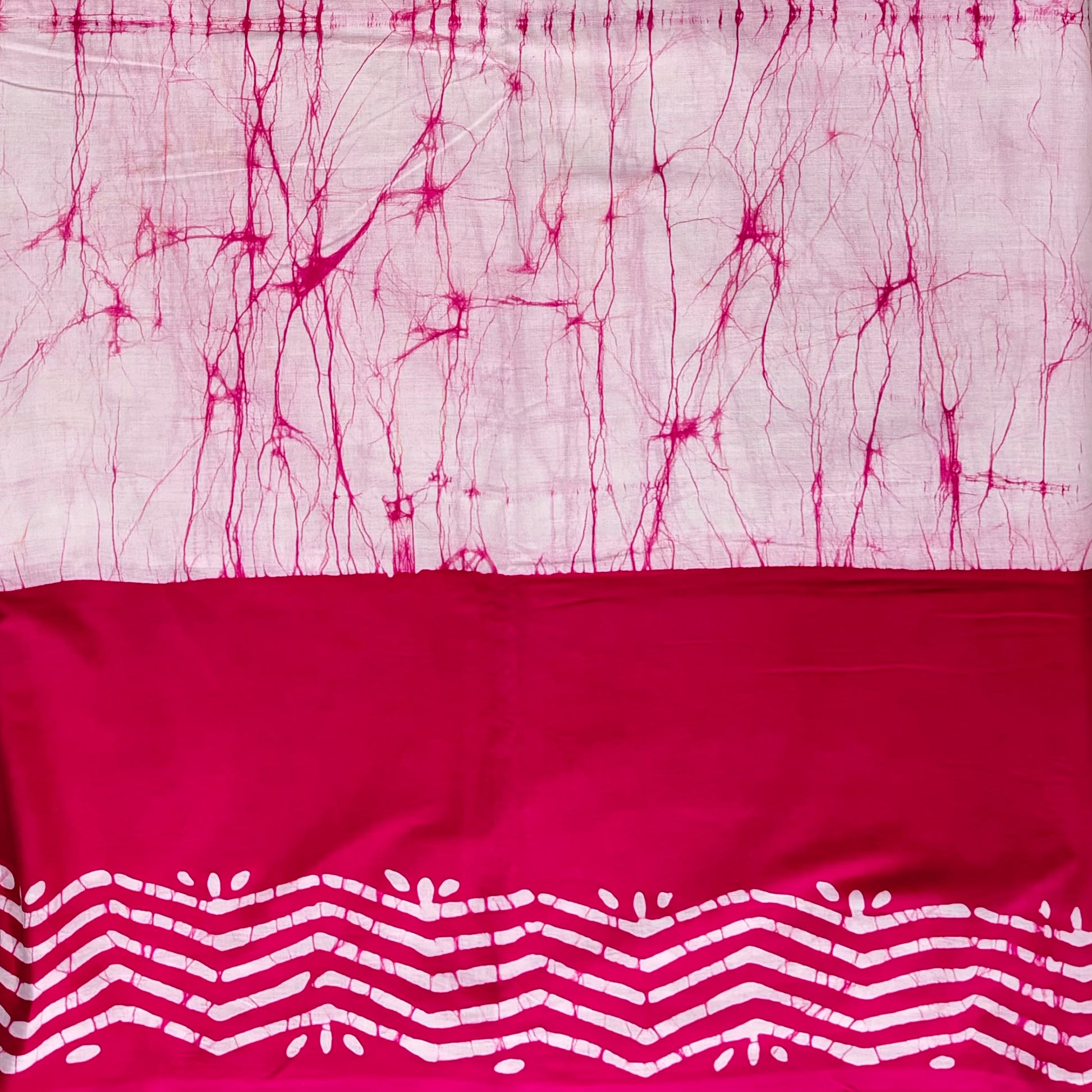 Cotton saree with light pink body and dark pink border. Body has dark pink thread like batik lines and border has white batik zigzag patterns.