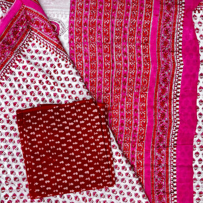 Close up of cotton saree in white base with pink and red floral block printed bootis and contrasting red blouse material with white booti.