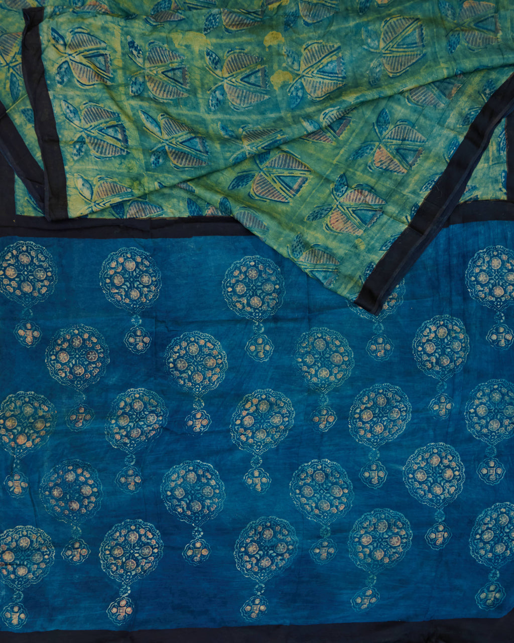 A green and blue combination tussar by modal saree in dabu handblock.