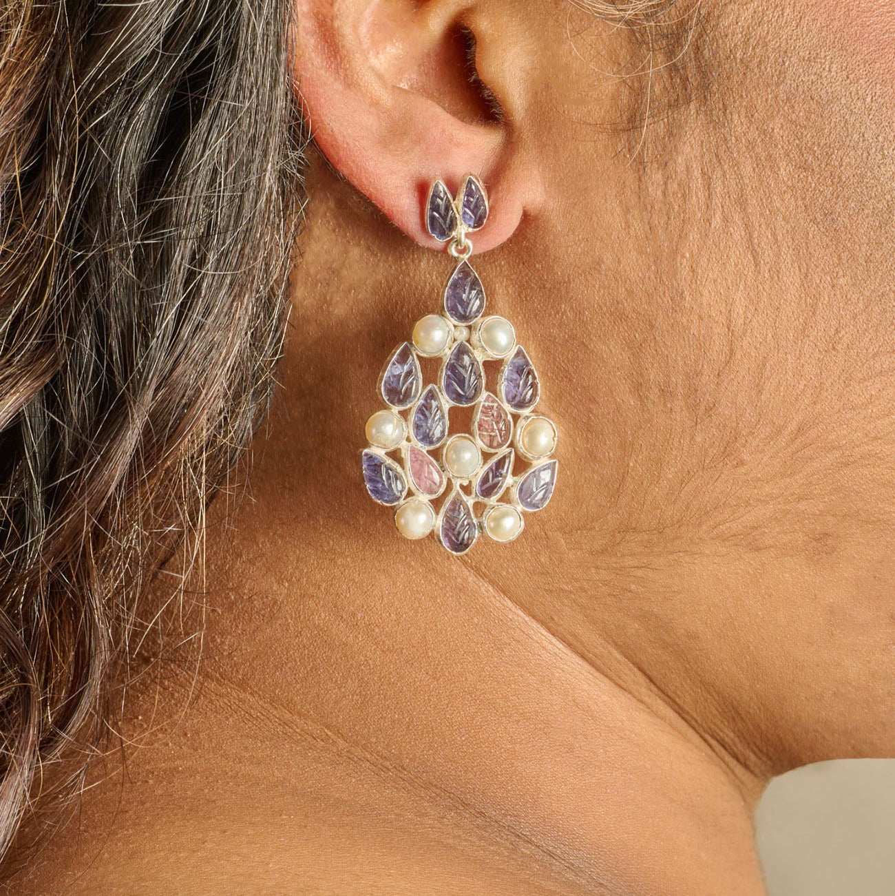 A silver earring with leaf shape carved tanzanite & pearls in bezel setting.