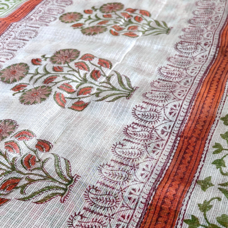 Close up of block printed kota silk saree with white base and orange and green florals.