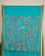 Turquoise blue Kosa silk saree with intricate Lambani embroidery on pallu on display.
