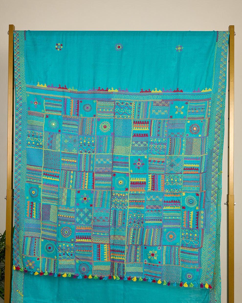 Turquoise blue Kosa silk saree with intricate Lambani embroidery on pallu on display.