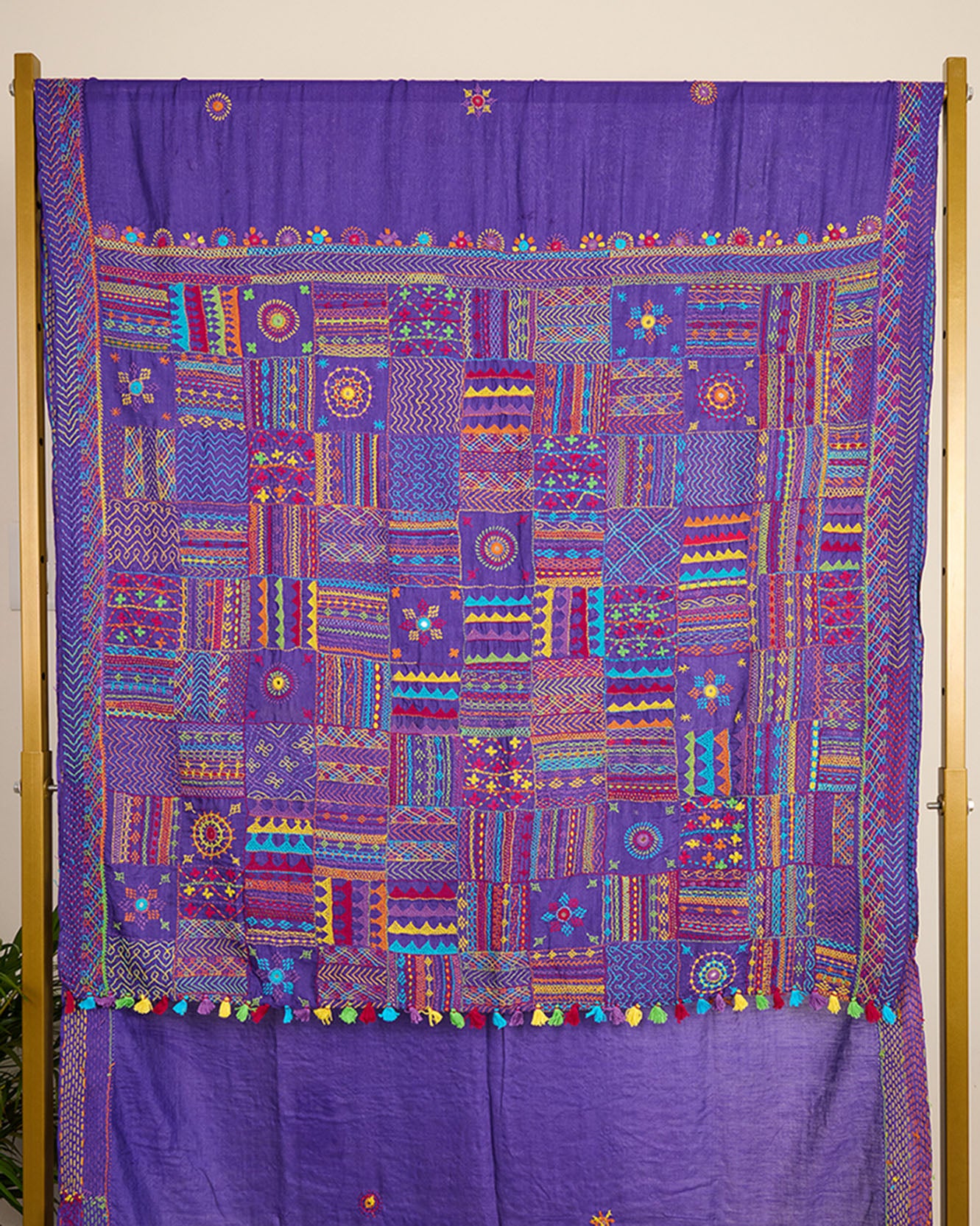 Purple Kosa silk saree with intricate Lambani embroidery on pallu and booti on body of the saree on display.