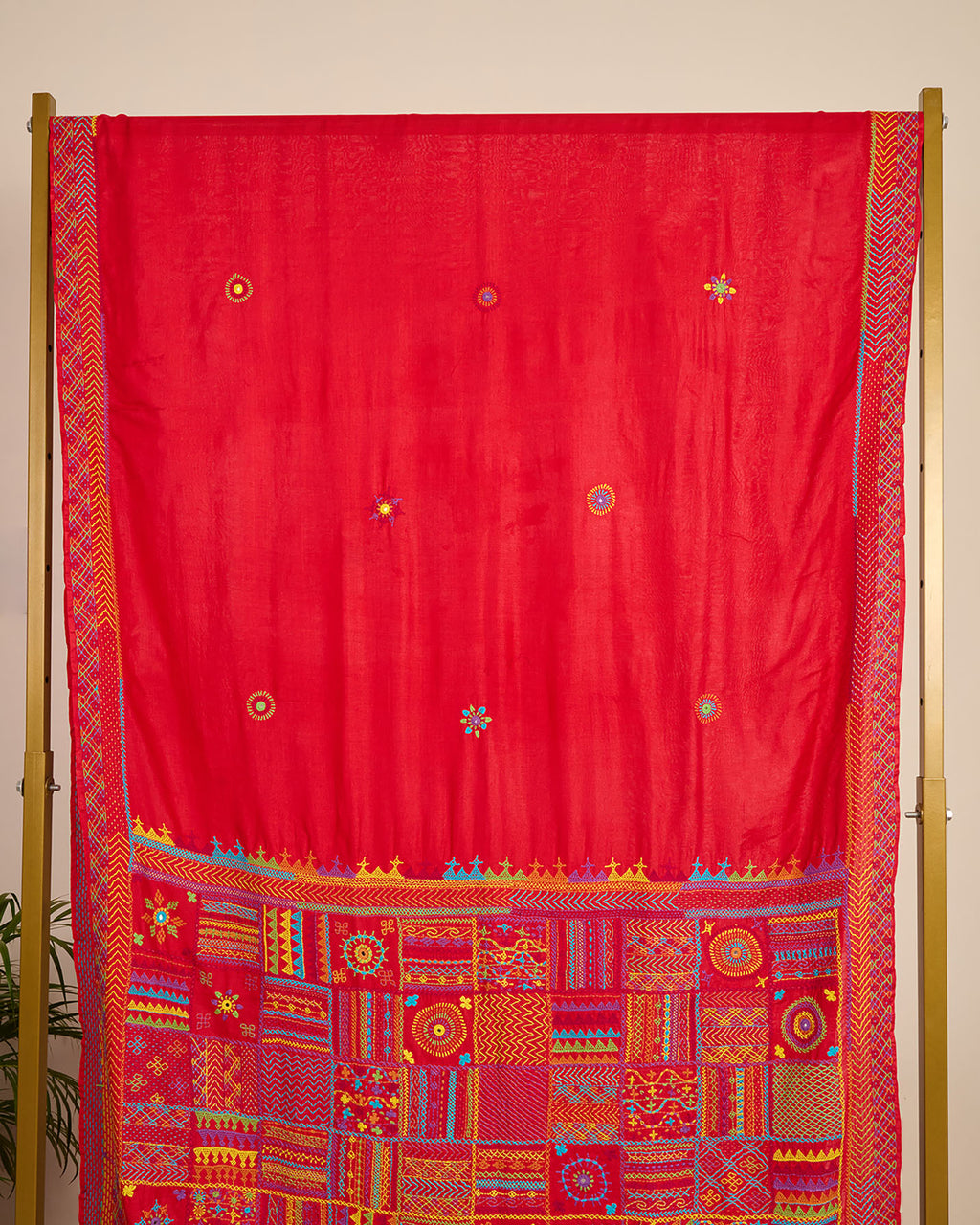 Red Kosa silk saree with intricate Lambani embroidery on pallu and booti on body of the saree on display.