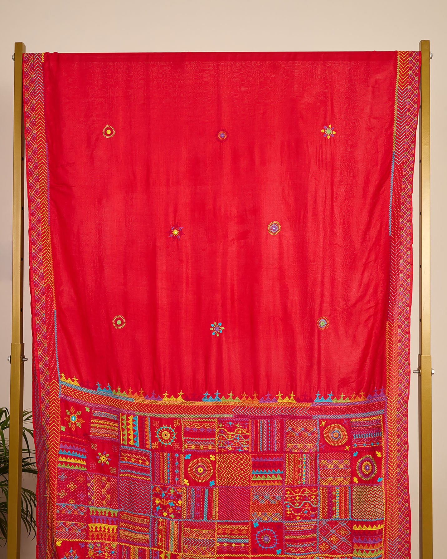 Red Kosa silk saree with intricate Lambani embroidery on pallu and booti on body of the saree on display.