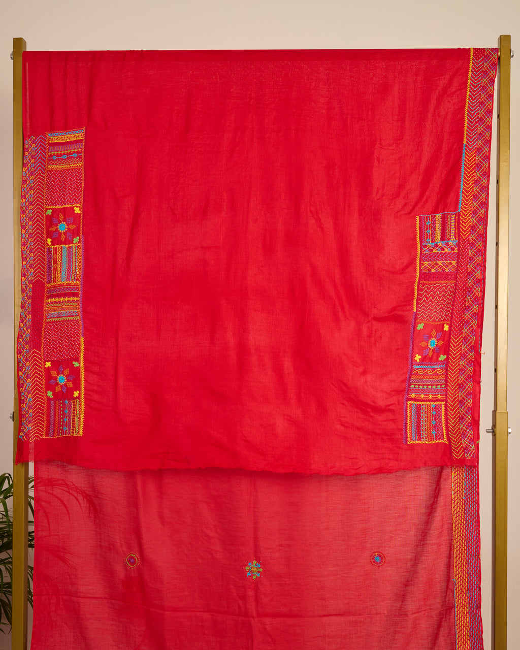 Red Kosa silk saree with intricate Lambani embroidery on the blouse material on display.