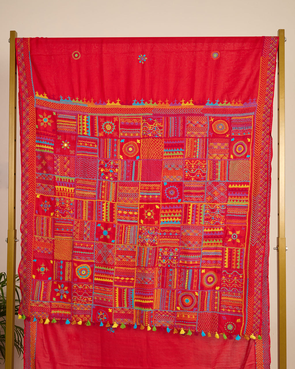 Red Kosa silk saree with intricate Lambani embroidery on pallu of the saree on display.