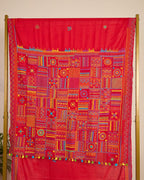 Red Kosa silk saree with intricate Lambani embroidery on pallu of the saree on display.