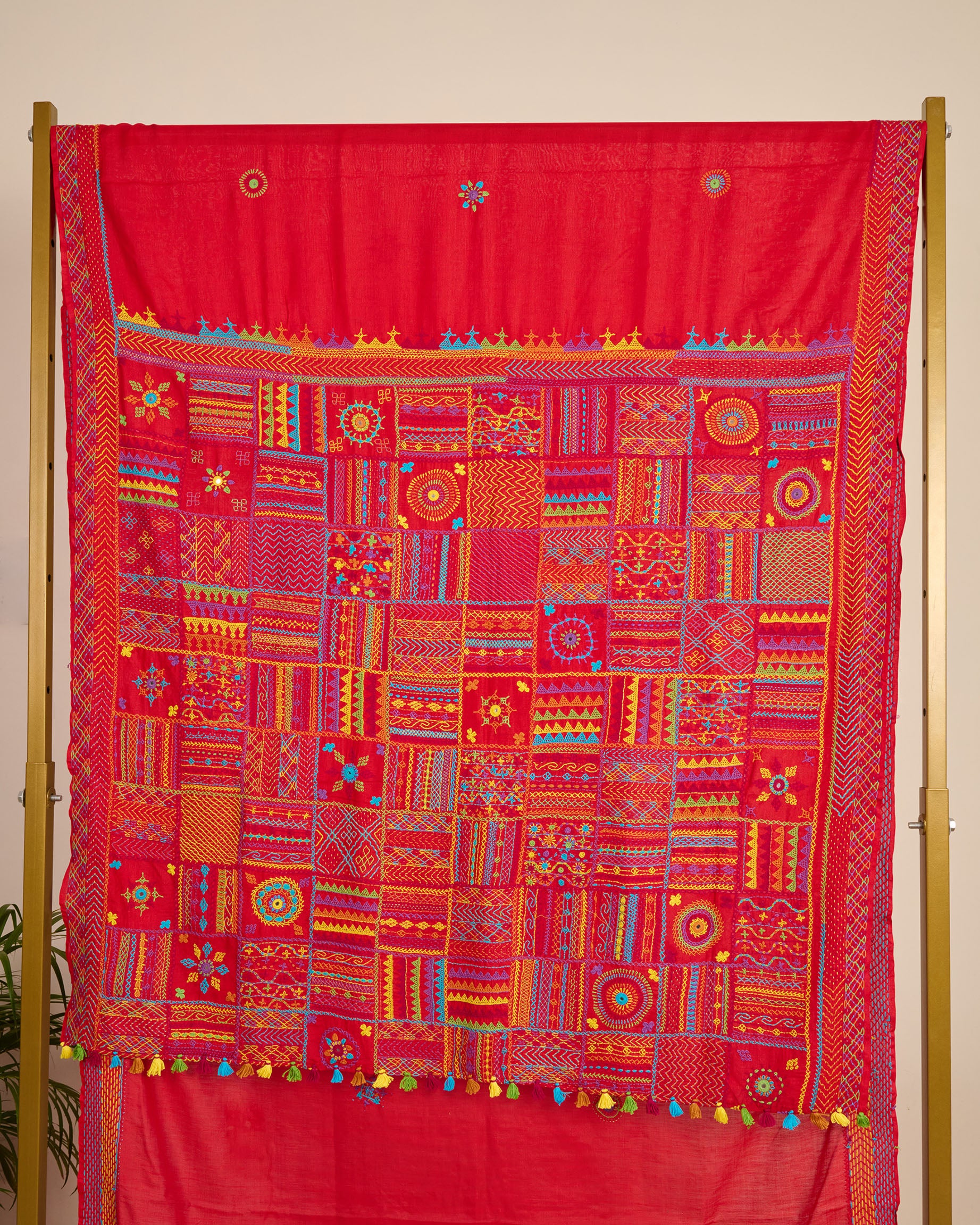 Red Kosa silk saree with intricate Lambani embroidery on pallu of the saree on display.