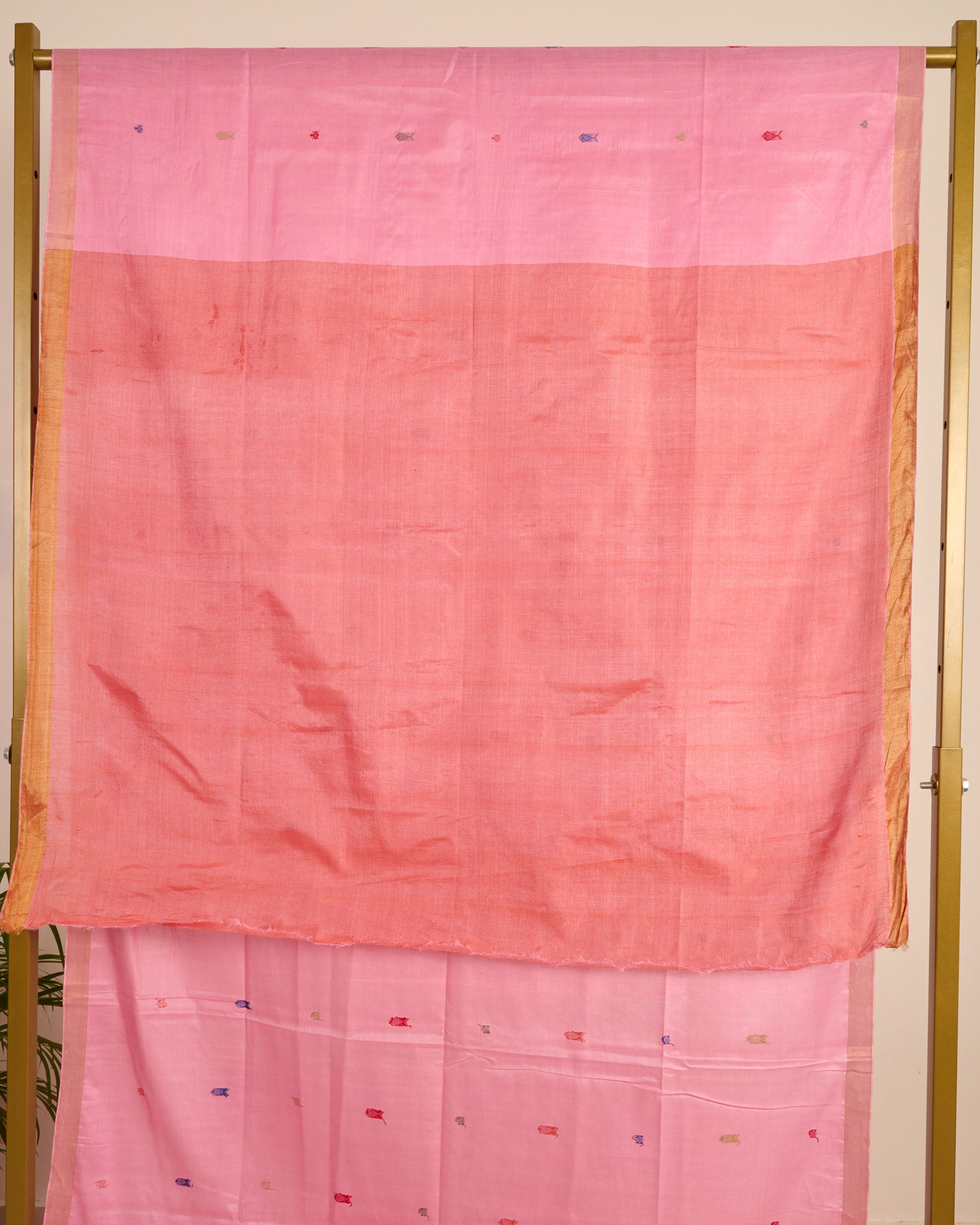 Pink Kosa Silk saree with traditional silk thread motifs displayed on a stand.