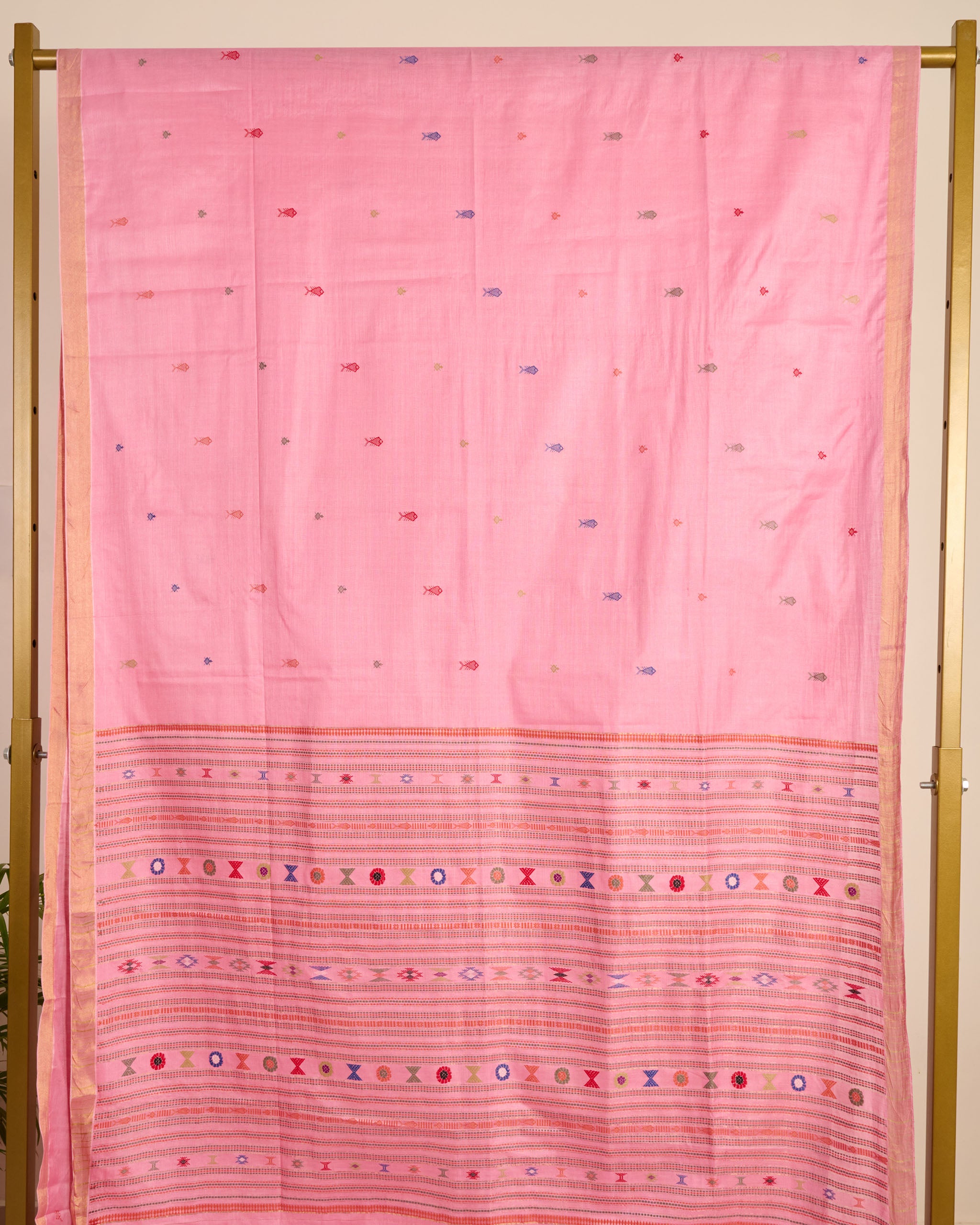 Pink Kosa Silk saree with traditional silk thread motifs displayed on a stand.