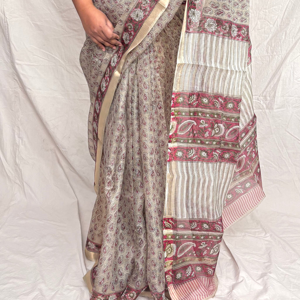Grey kota silk bagru block print saree with pink paisley booti all over and floral border.