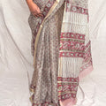 Grey kota silk bagru block print saree with pink paisley booti all over and floral border.