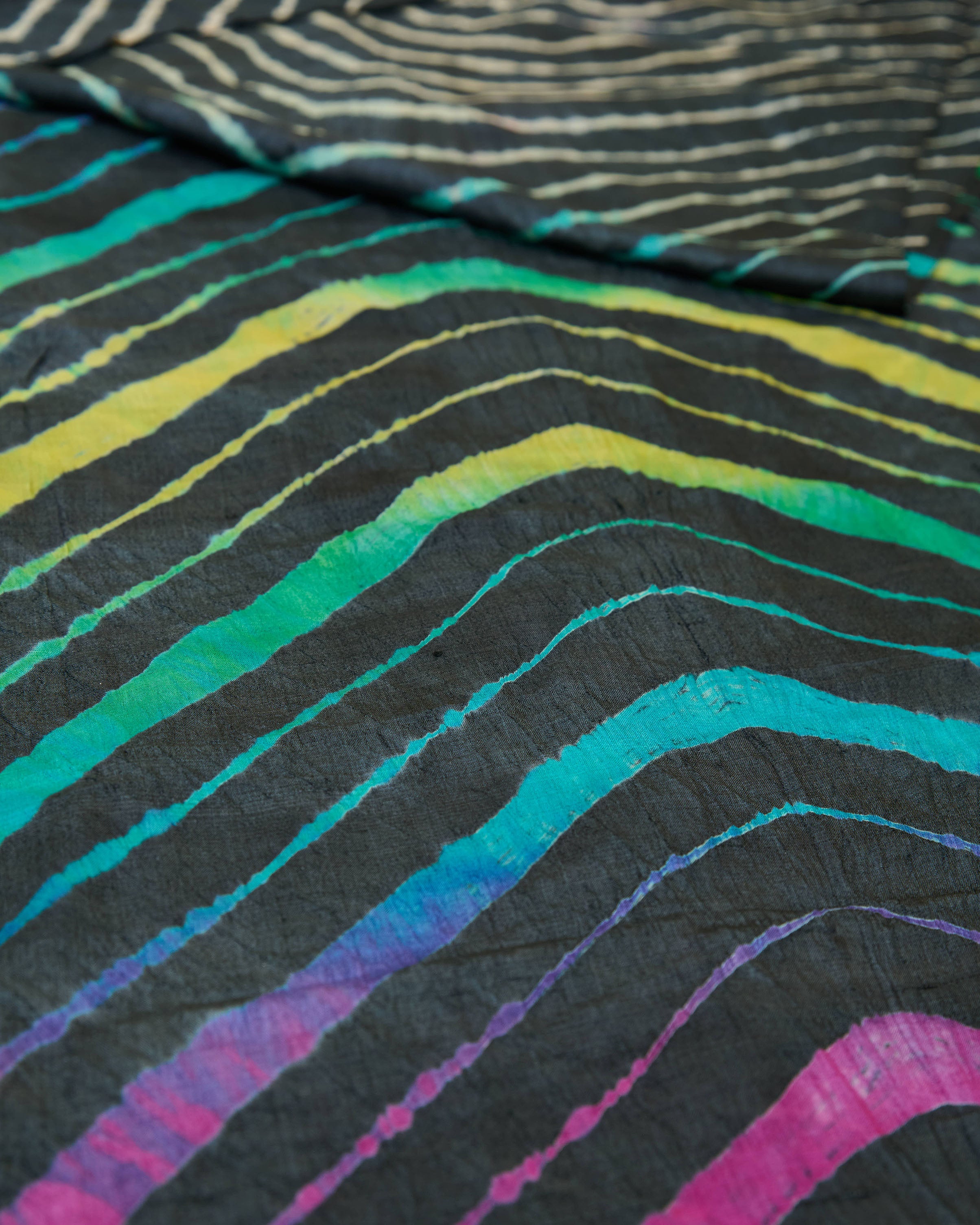 Close up of a black leheriya saree with multicolour leheriya