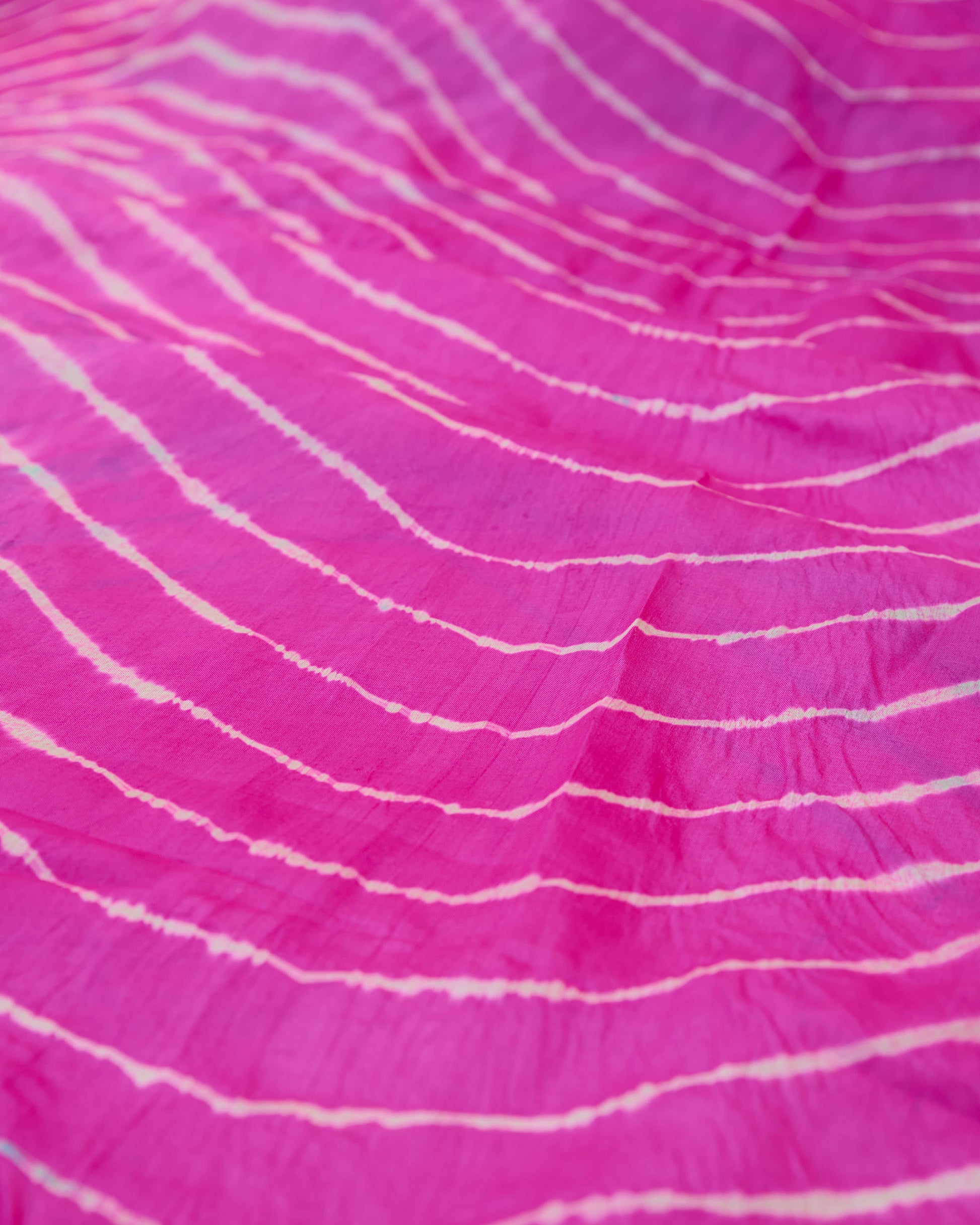 A pink toned leheriya close up of the saree