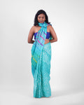 A model wearing a turquoise blue leheriya saree in tussar, with the pallu styled as a stole around her neck. 