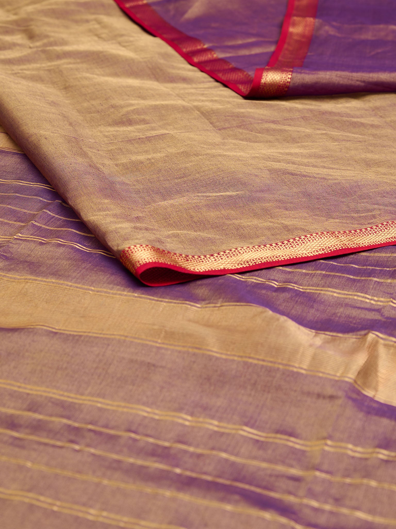 A dual tone Maheshwari Tissue saree in violet and gold displayed