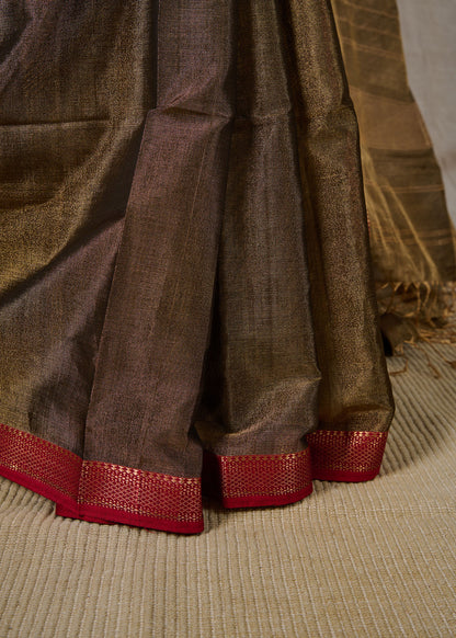 Neat pleats of a maheshwari tissue saree in dual tone of black and gold on showcase.