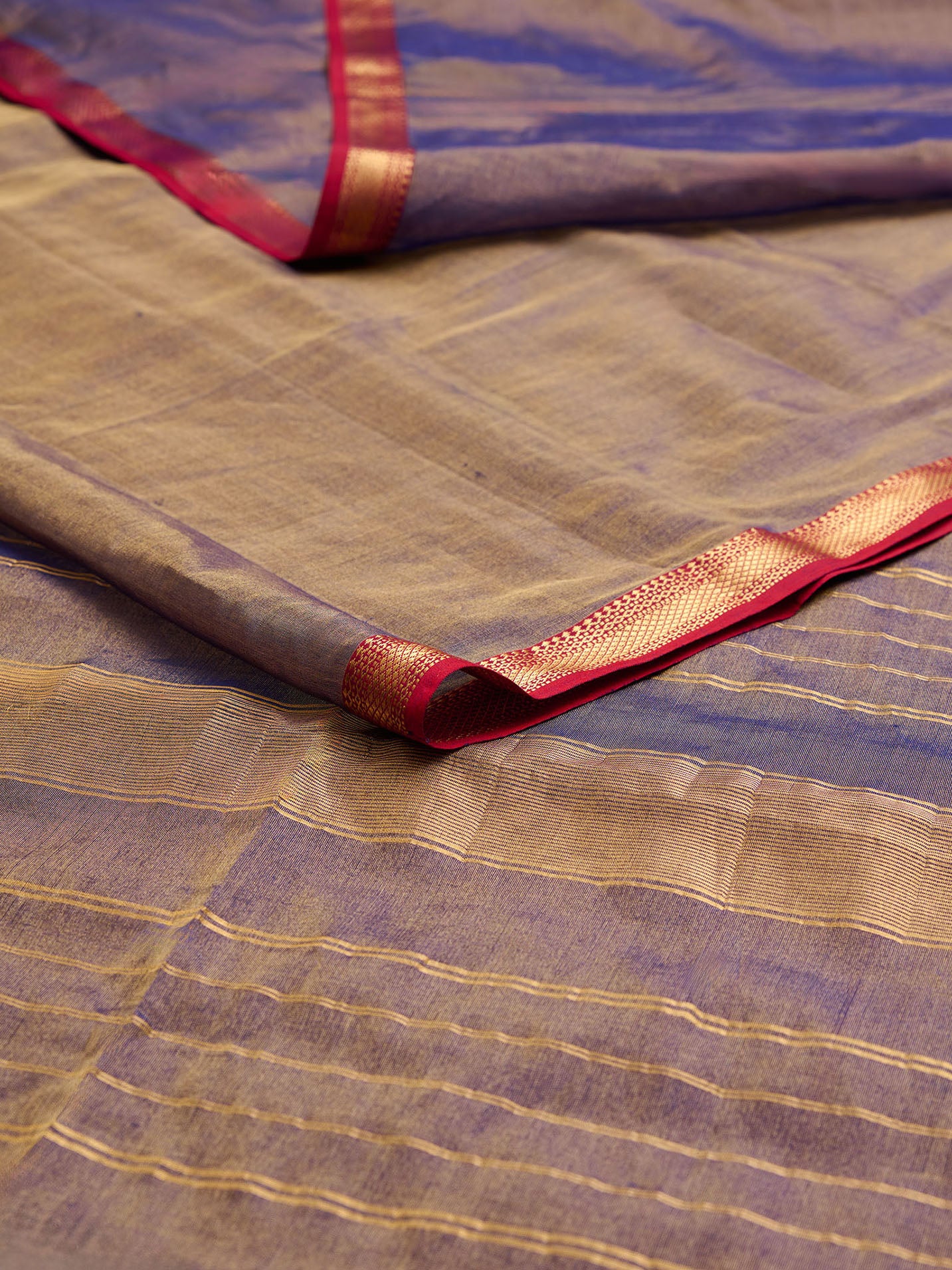 Maheshwari tissue saree in dual tone blue and gold laid out with it's border in focus.