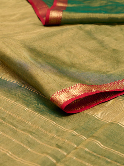 A maheshwari tissue saree in dual tone of dark green and gold displayed on a flat surface.