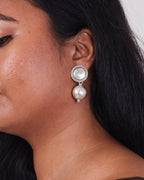 Model wearing a classic and clean design of silver ball drop earrings on her left ear. 