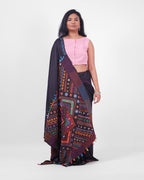 Model showcasing a black saree with colourful Lambani embroidery with an ornate pallu draped in the front. 