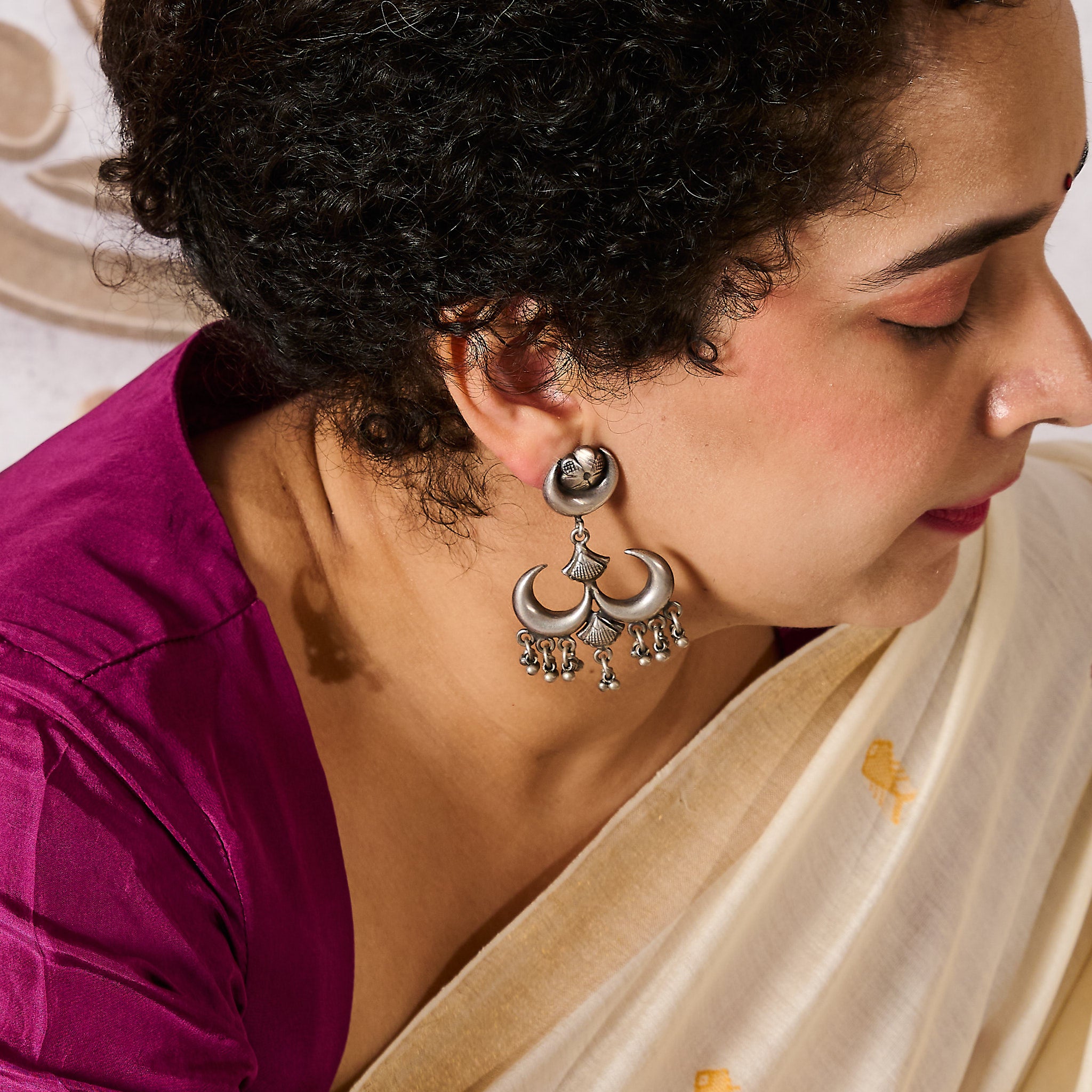 Woman wearing a silver chandrama chandbaali earring in a traditional attire