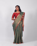 A model wearing our tissue silk maheshwari saree in the colour dark green, with a traditional chasm-e-bulbul (diamond) border of maheshwari weaves. 