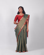 A model wearing our tissue silk maheshwari saree in the colour dark green, with a traditional chasm-e-bulbul (diamond) border of maheshwari weaves. 