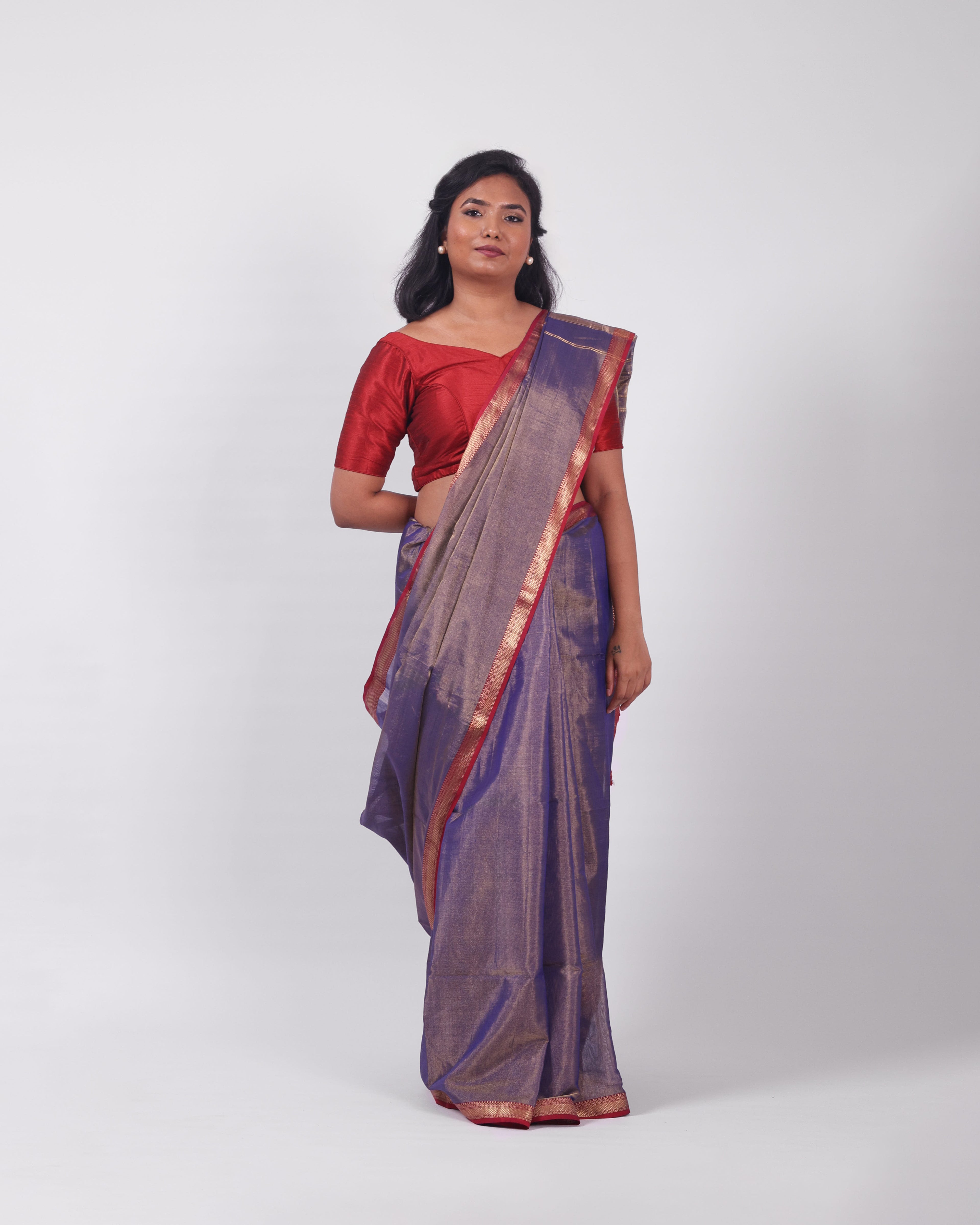 A model wearing our tissue silk maheshwari saree in the colour blue, with a traditional chasm-e-bulbul (diamond) border of maheshwari weaves. 