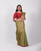 A model wearing our tissue silk maheshwari saree in the colour light green, with a traditional chasm-e-bulbul (diamond) border of maheshwari weaves. 