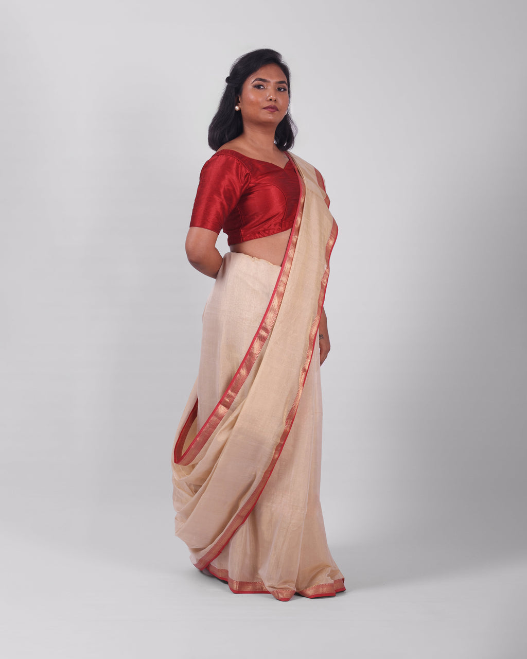 A model wearing our tissue silk maheshwari saree in the colour off white, with a traditional chasm-e-bulbul (diamond) border of maheshwari weaves. 