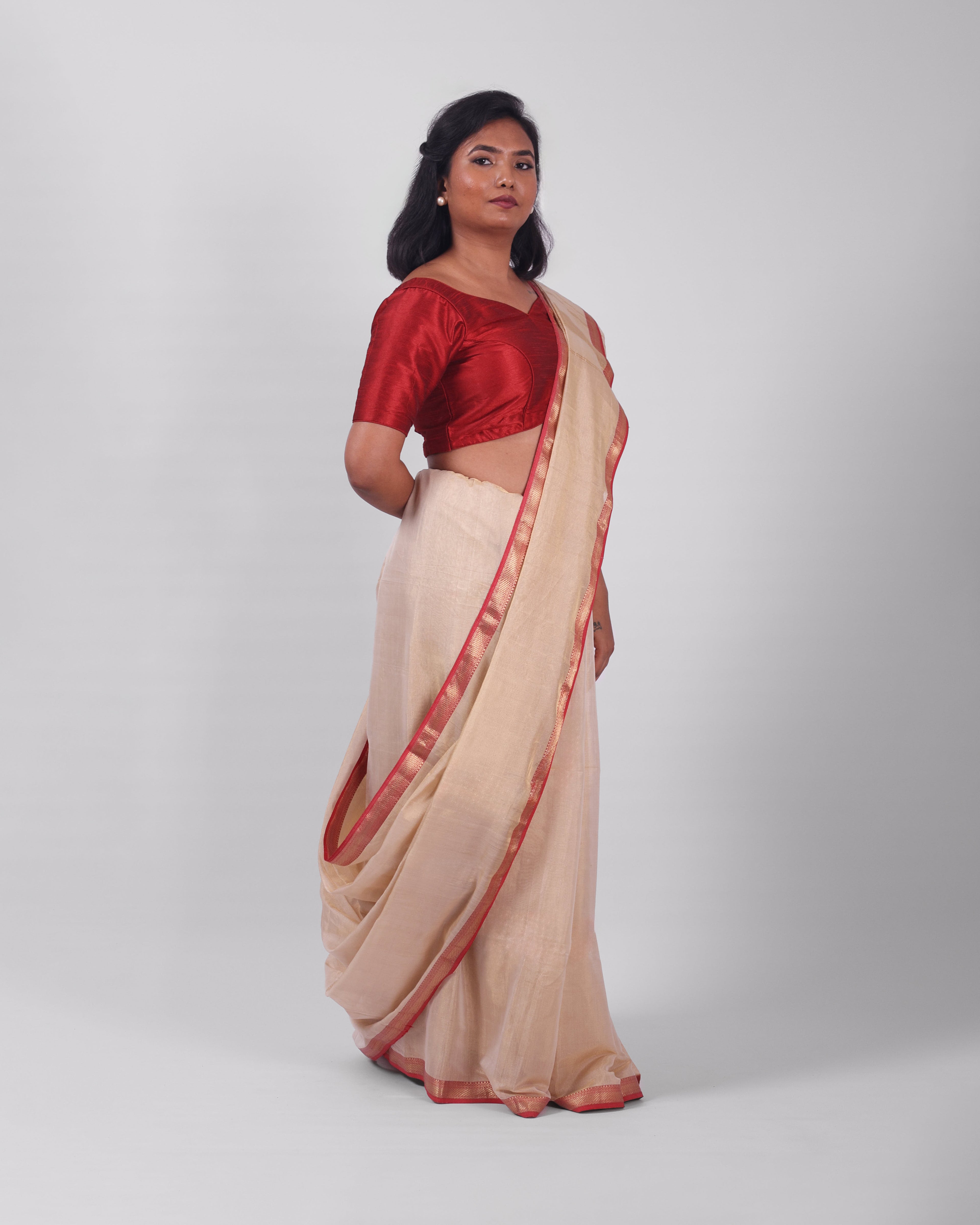 A model wearing our tissue silk maheshwari saree in the colour off white, with a traditional chasm-e-bulbul (diamond) border of maheshwari weaves. 