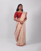 A model wearing our tissue silk maheshwari saree in the colour off white, with a traditional chasm-e-bulbul (diamond) border of maheshwari weaves. 