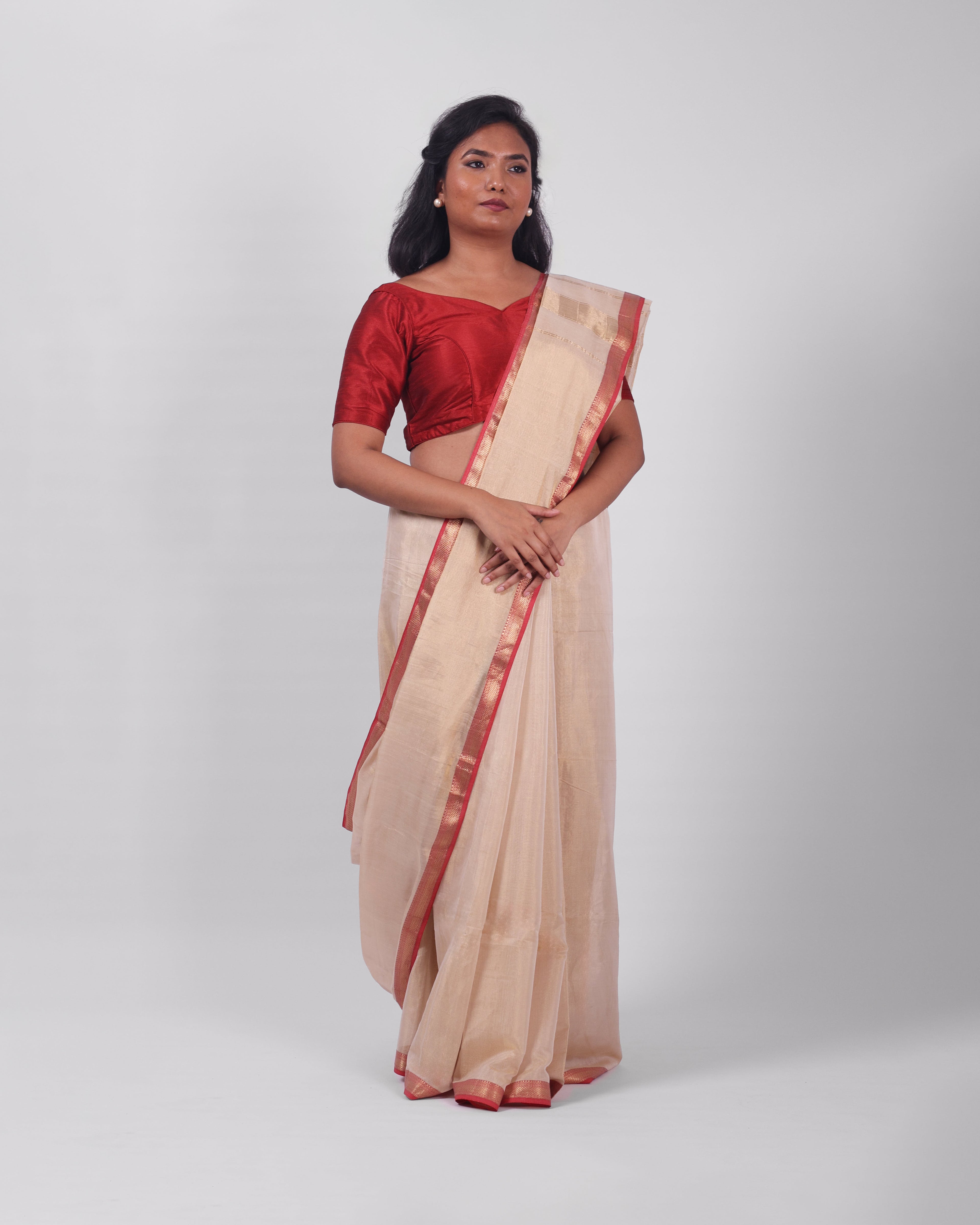 A model wearing our tissue silk maheshwari saree in the colour off white, with a traditional chasm-e-bulbul (diamond) border of maheshwari weaves. 