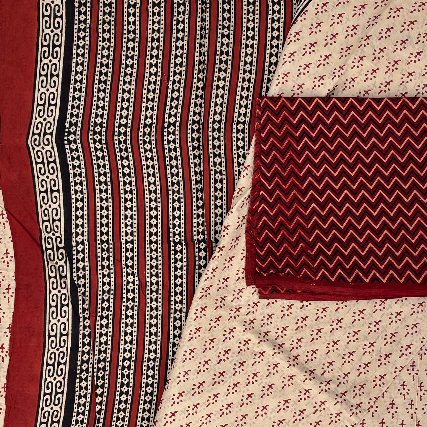 Beige coloured base fabric cotton saree with red all over booti and contrasting red blockprinted blouse material.