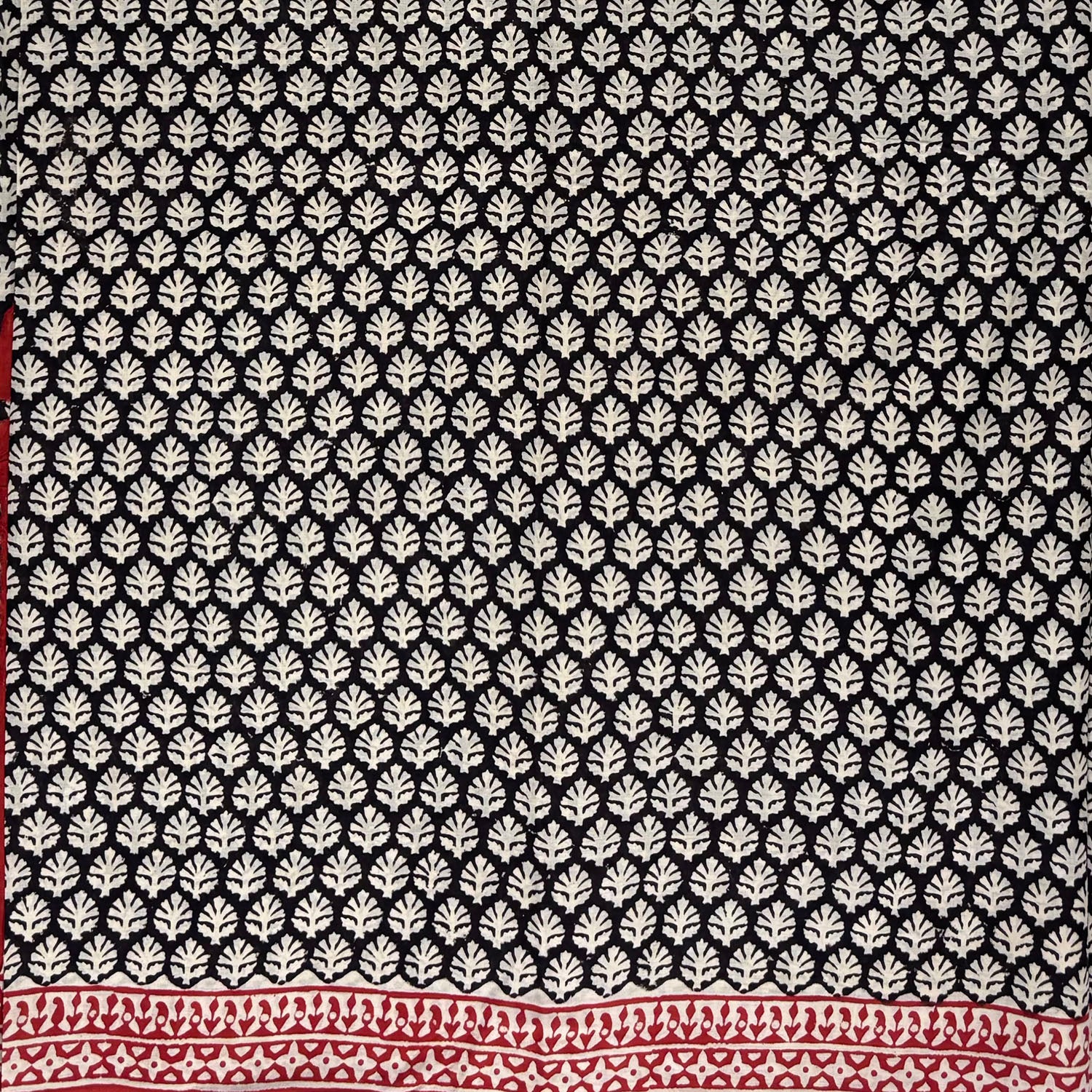 Black base cotton block printed saree with beige booti print all over and red border.