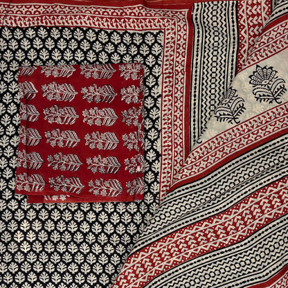 Black base colour cotton blockprinted saree with beige booti and red border and contrasting red blockprinted blouse material.