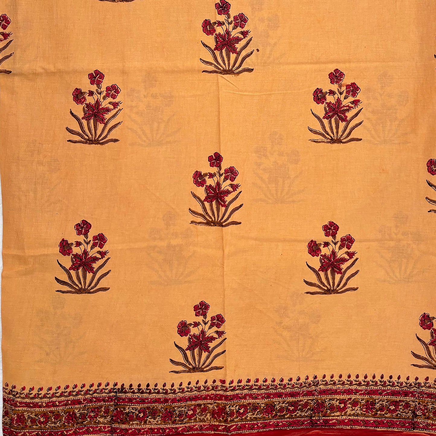 Fawn colour cotton saree with Mughal floral block print all over and a red border.