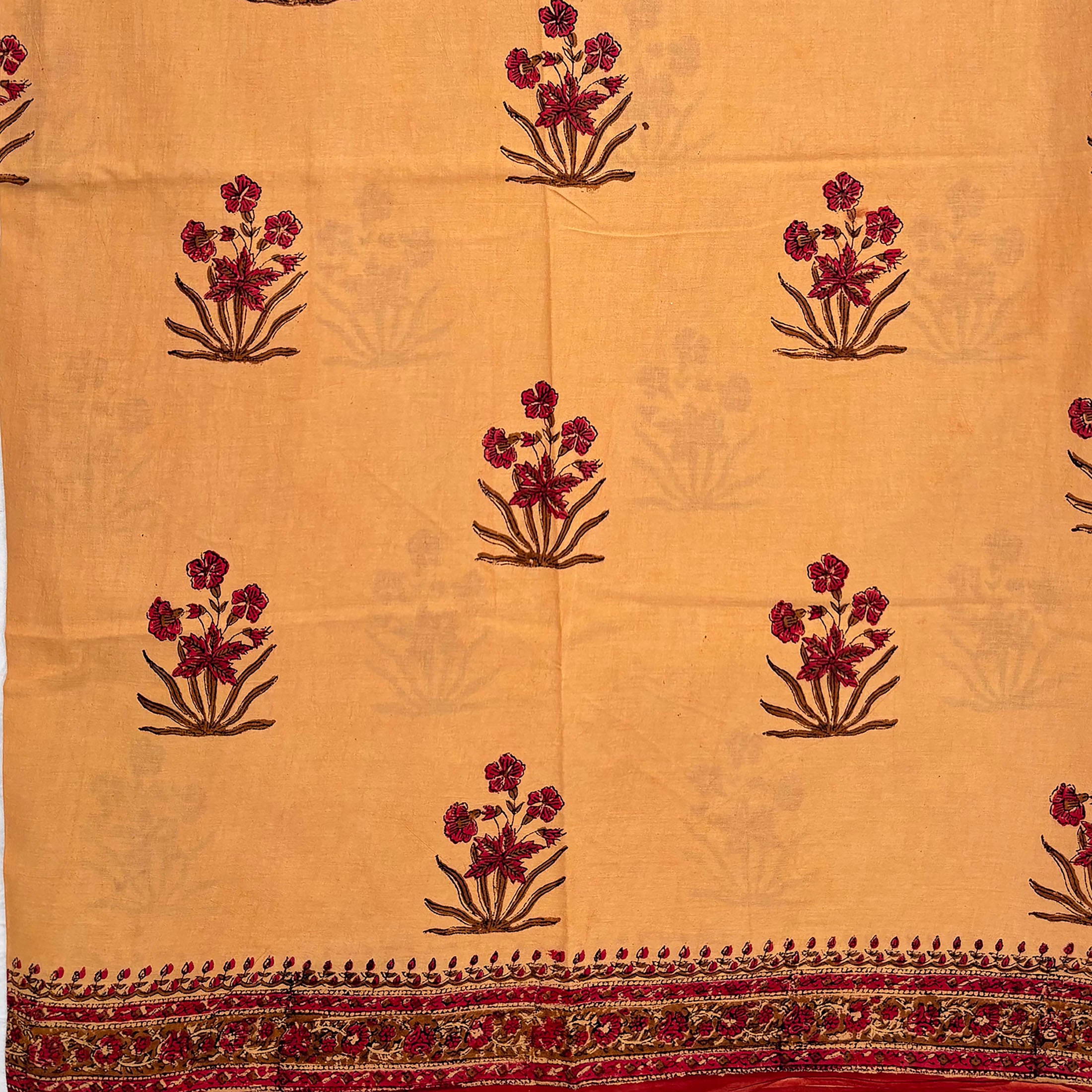 Fawn colour cotton saree with Mughal floral block print all over and a red border.