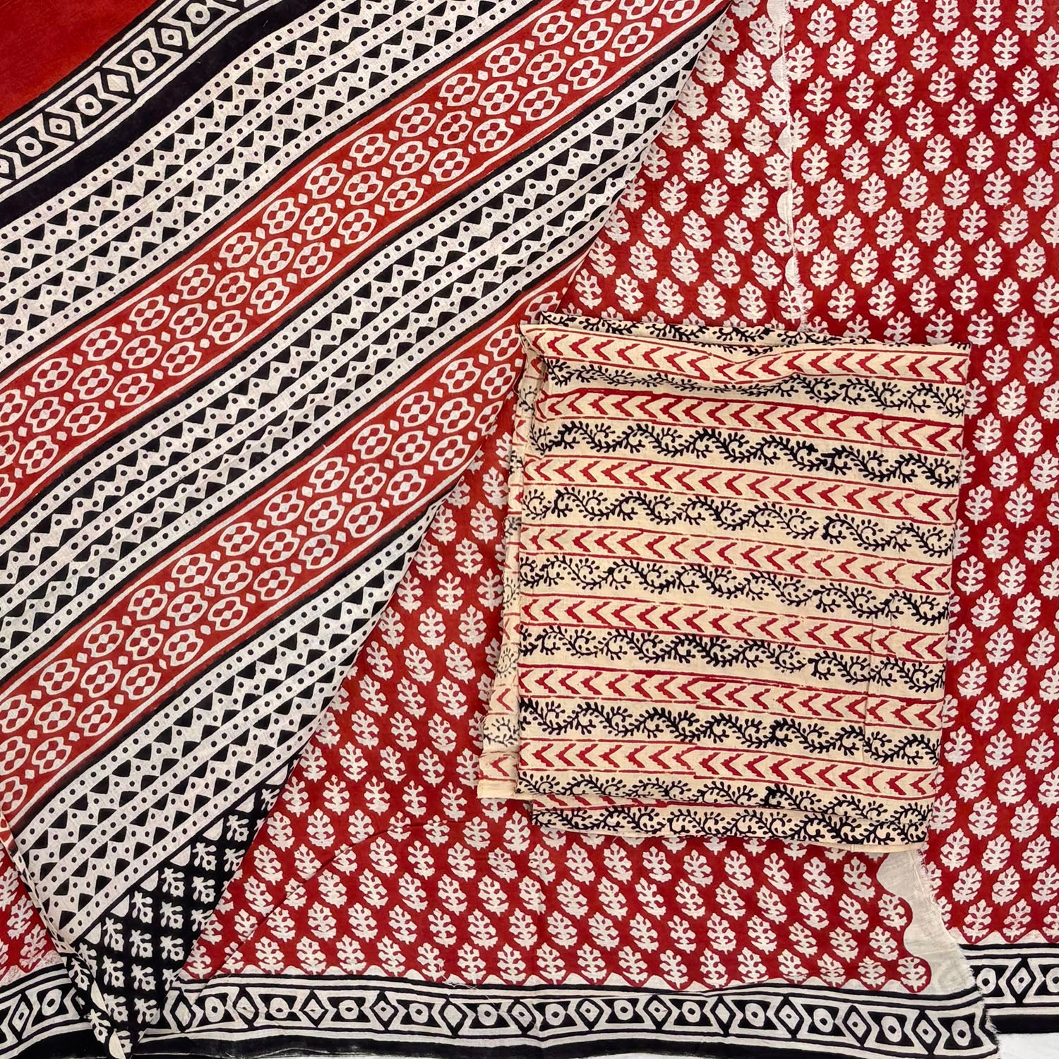 Red base colour cotton block printed saree with small beige floral booti all over, contrasting beige blockprinted blouse material and pallu on display.