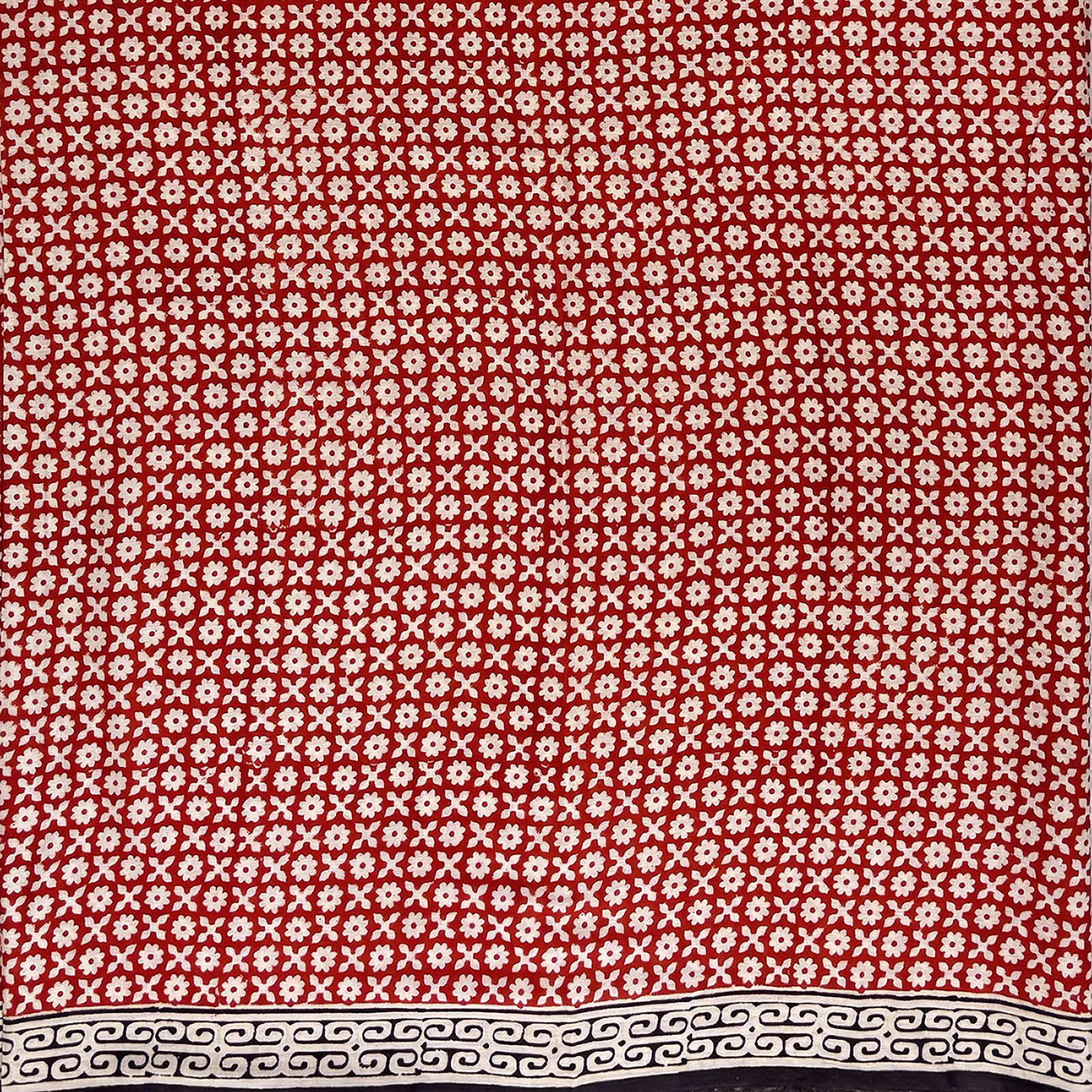 Red base colour cotton block printed saree with small beige flower booti print all over and a black border.