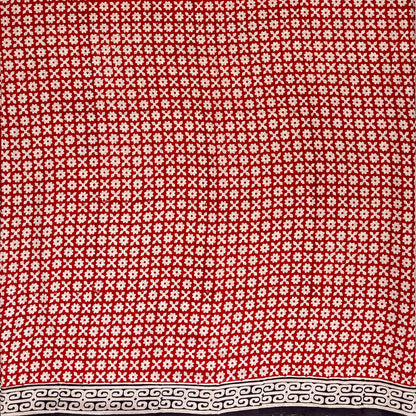Red base colour cotton block printed saree with small beige flower booti print all over and a black border.