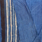 Indigo colour cotton saree with blockprinted stripes on the body and contrasting blouse material with dotted print. Pallu in white black and blue striped pattern.