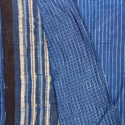 Indigo colour cotton saree with blockprinted stripes on the body and contrasting blouse material with dotted print. Pallu in white black and blue striped pattern.